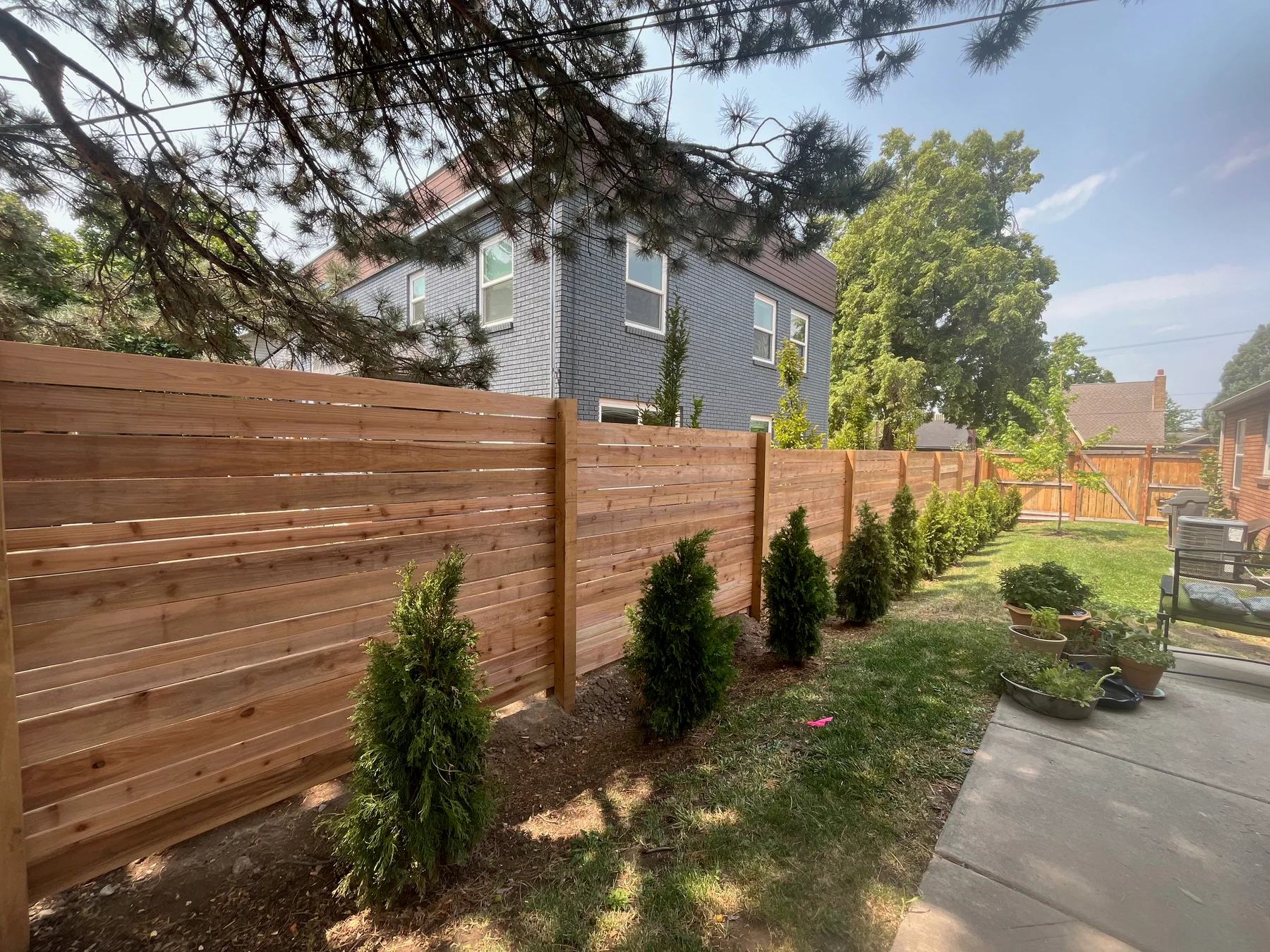Horizontal wood privacy fence behind fresh landscaping at a Utah home