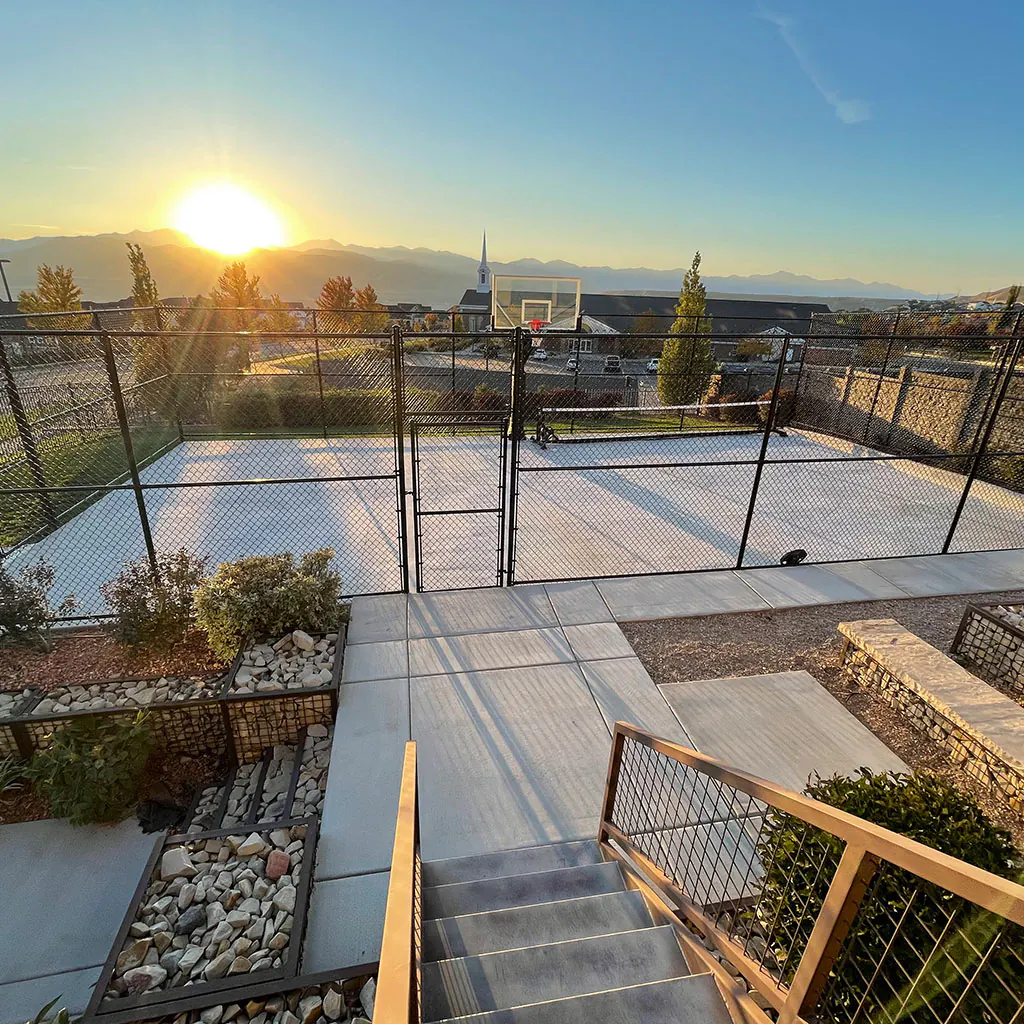 Black chain-link fence protecting a raised residential patio in Utah County