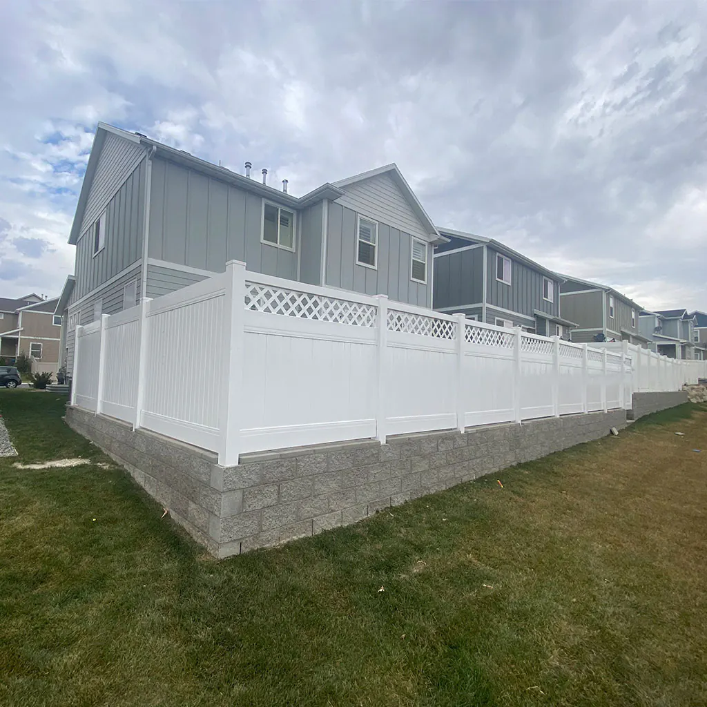 White lattice-top vinyl privacy fence around a corner lot in Utah County