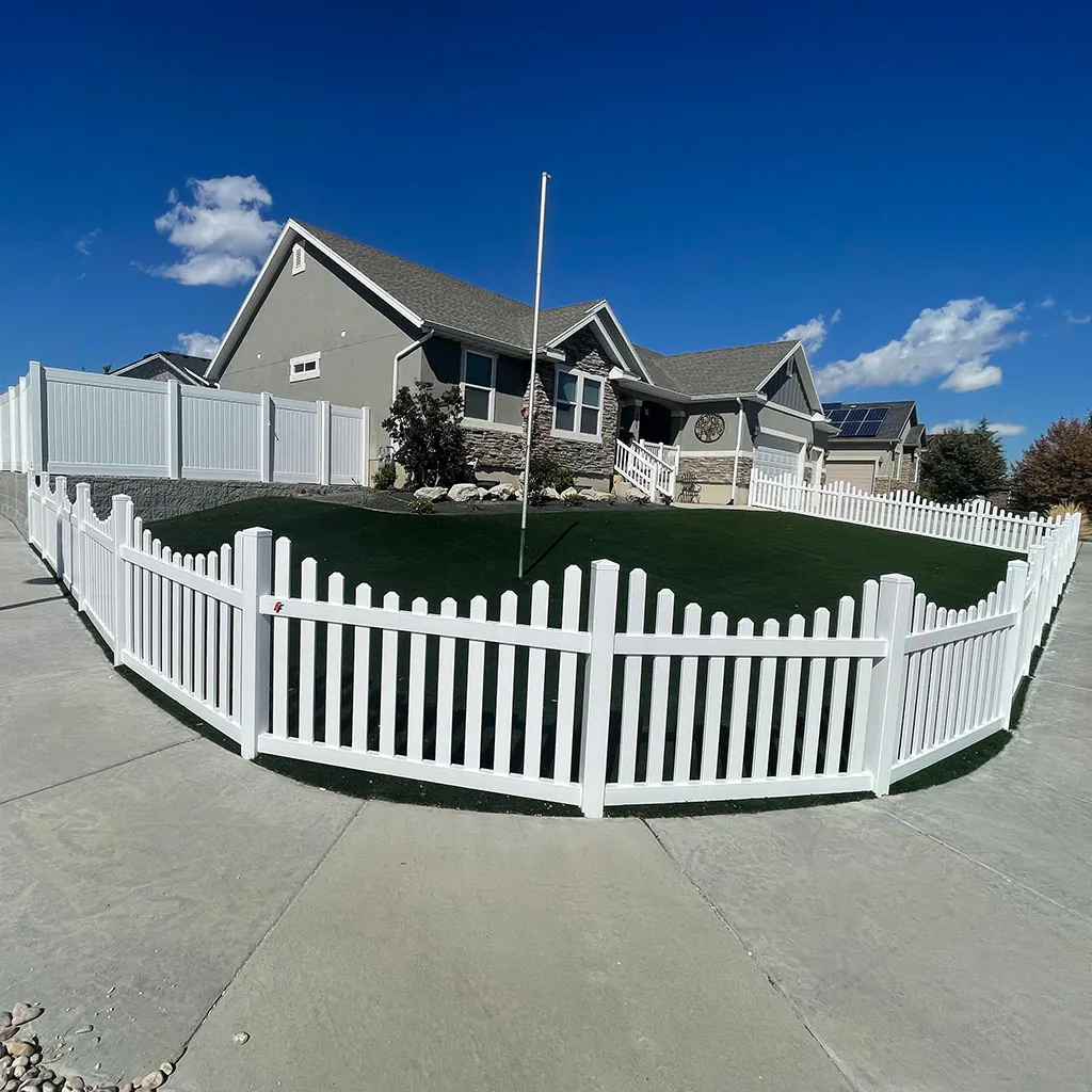 White vinyl picket fence surrounding a landscaped Utah County front yard