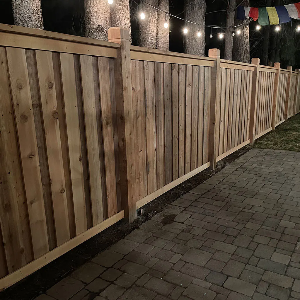 Finished cedar privacy fence with warm patio lights in Utah County