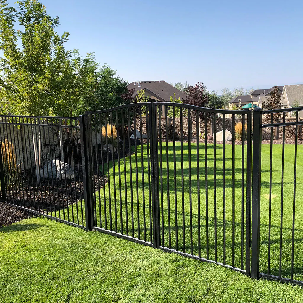 Black ornamental iron fence enclosing a lush Utah County backyard