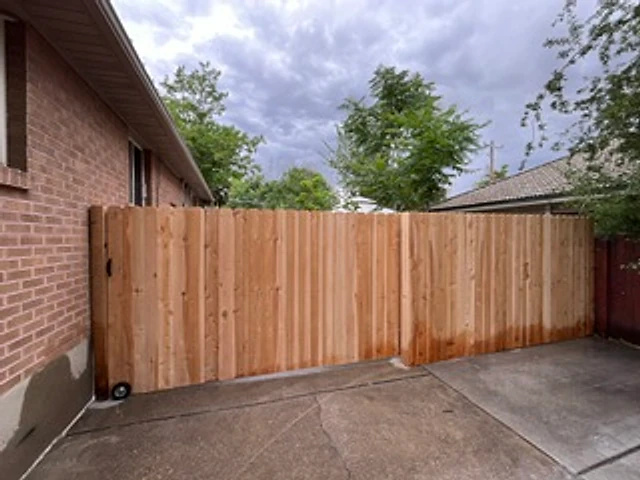 Brick-side cedar privacy gate installed at a Utah property
