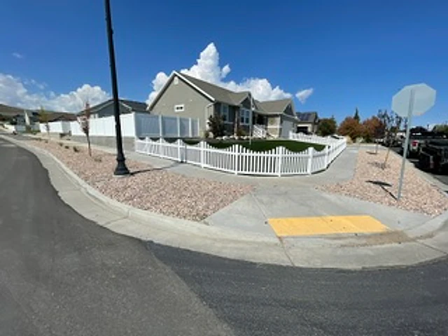 Corner-lot vinyl picket fence installed at a Utah property