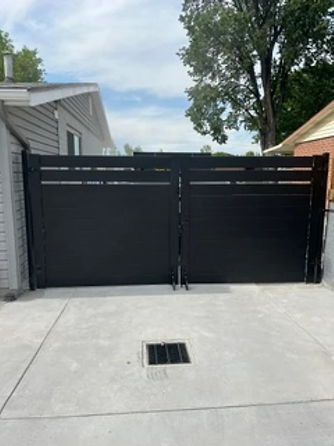 Modern black driveway gate installed at a Utah property