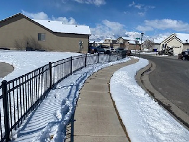 Snow-lined iron walkway installed at a Utah property